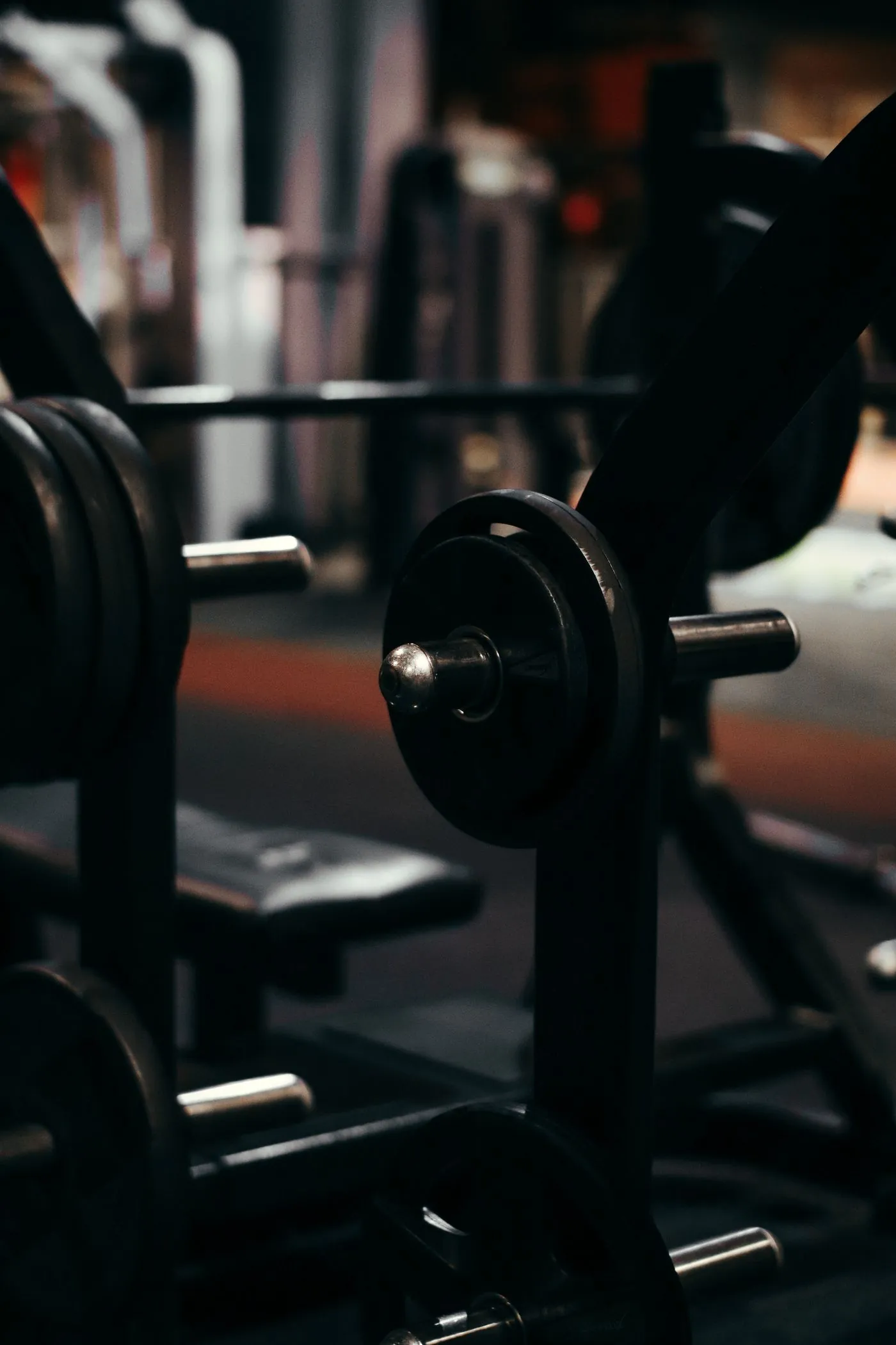 Weight plates and a bench in a low-lit gym