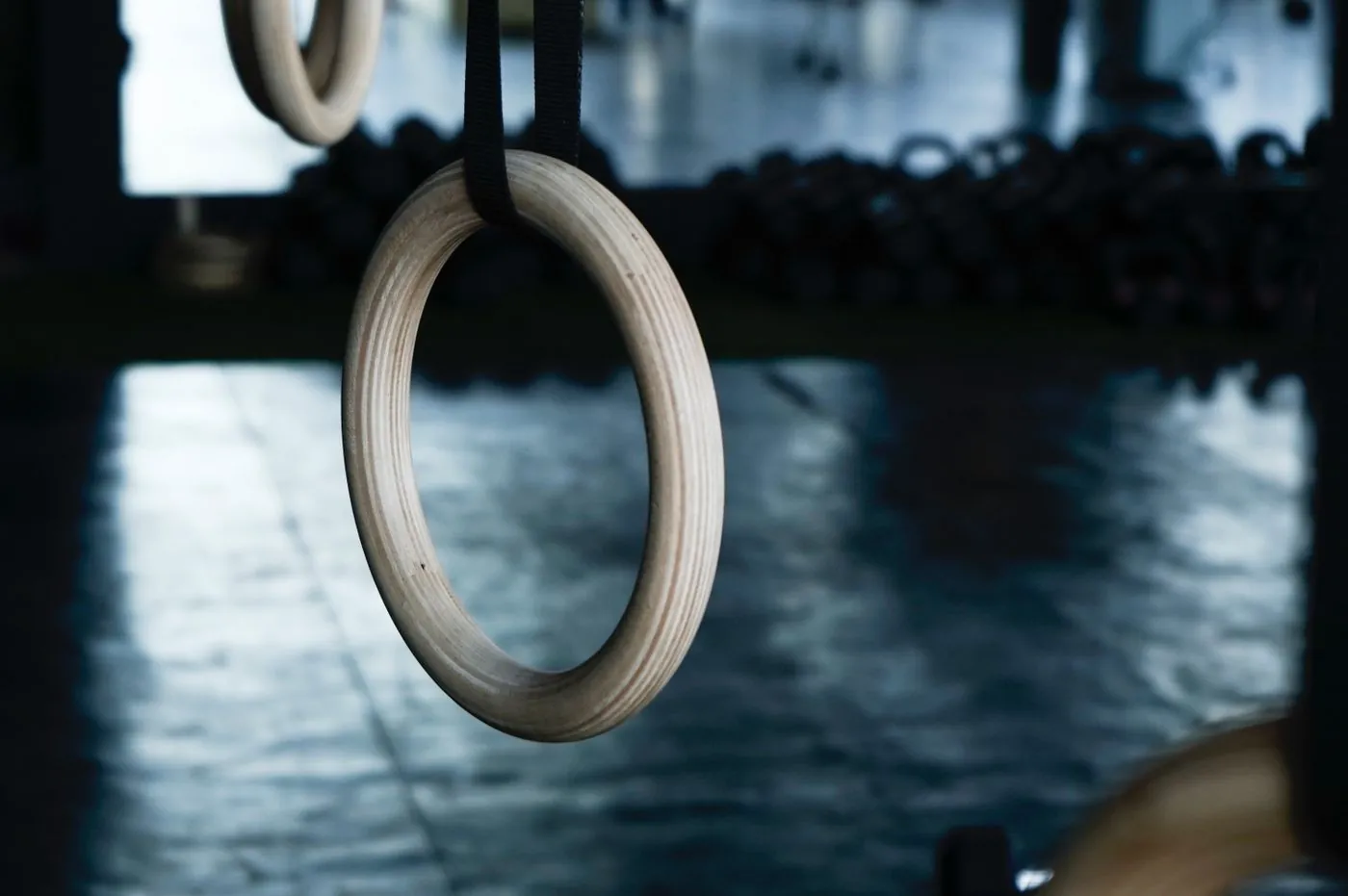 Wooden gymnastic rings hanging in a dark hall