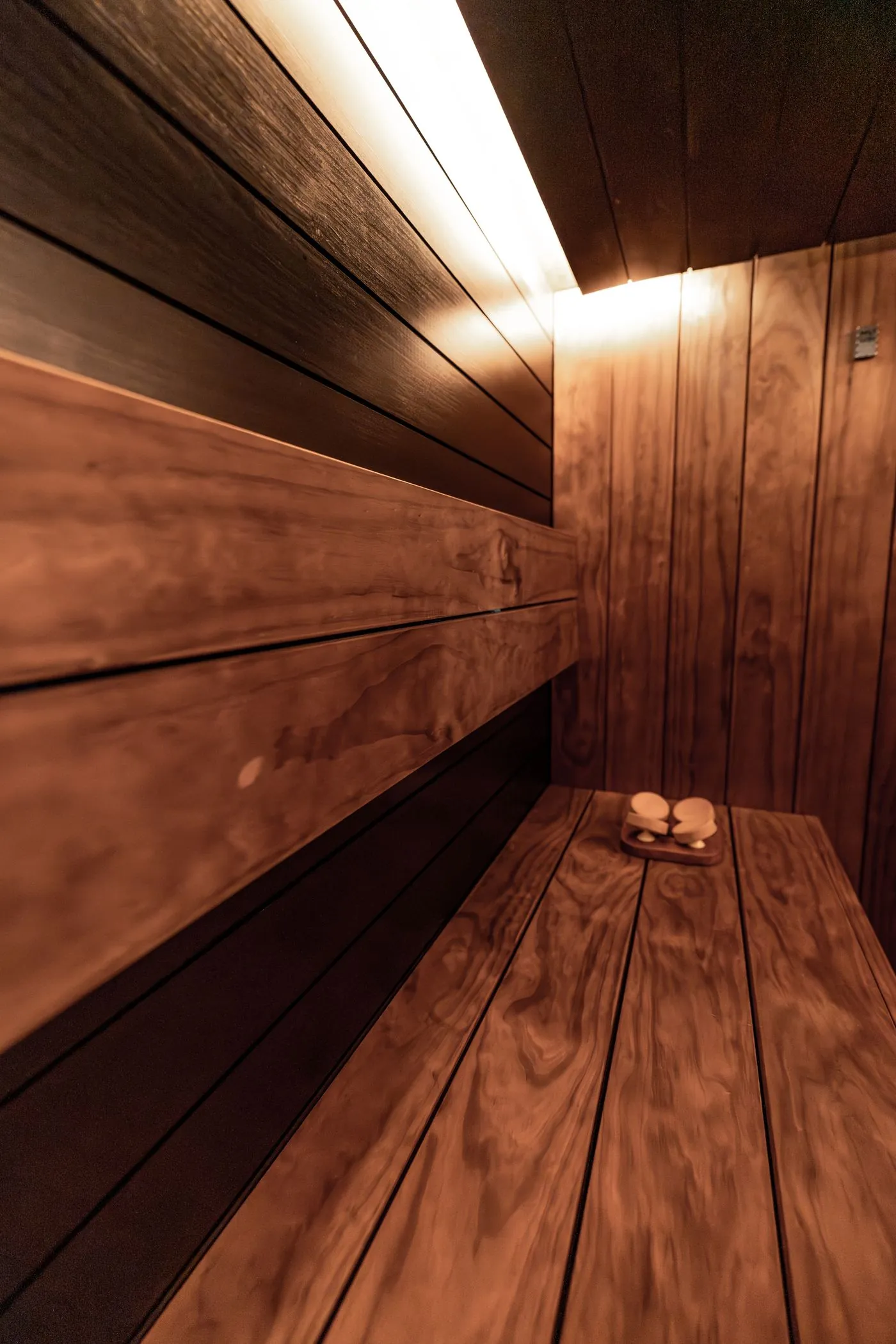 Interior of a wood-panelled sauna with warm downlighting