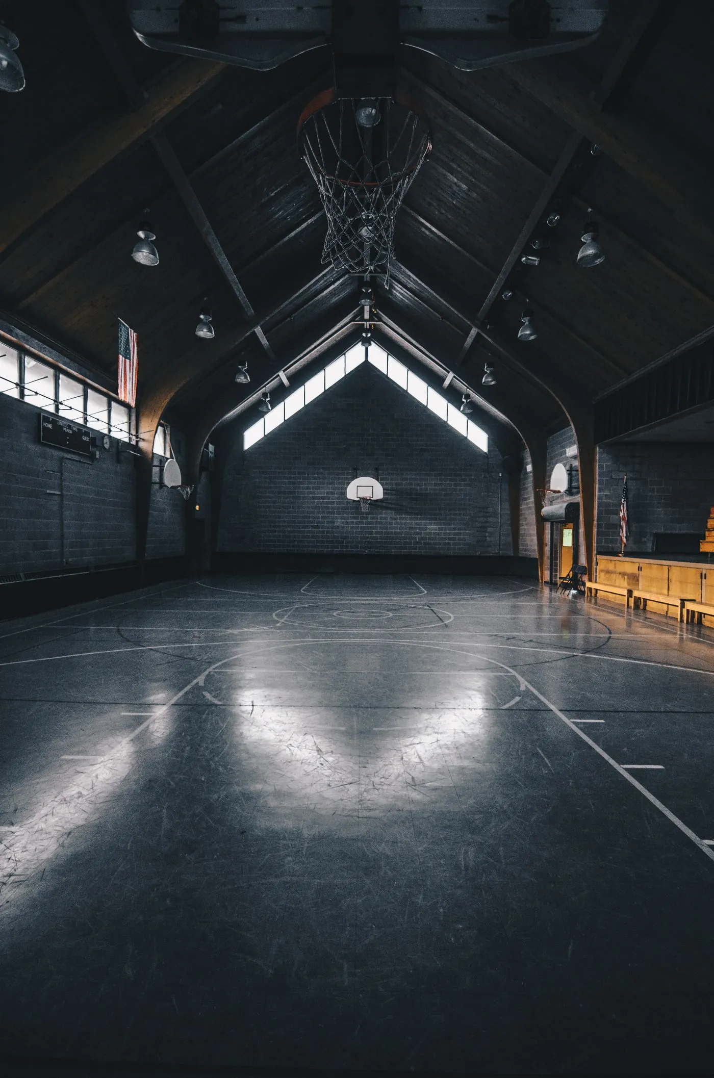 Empty indoor court lit from above in near darkness