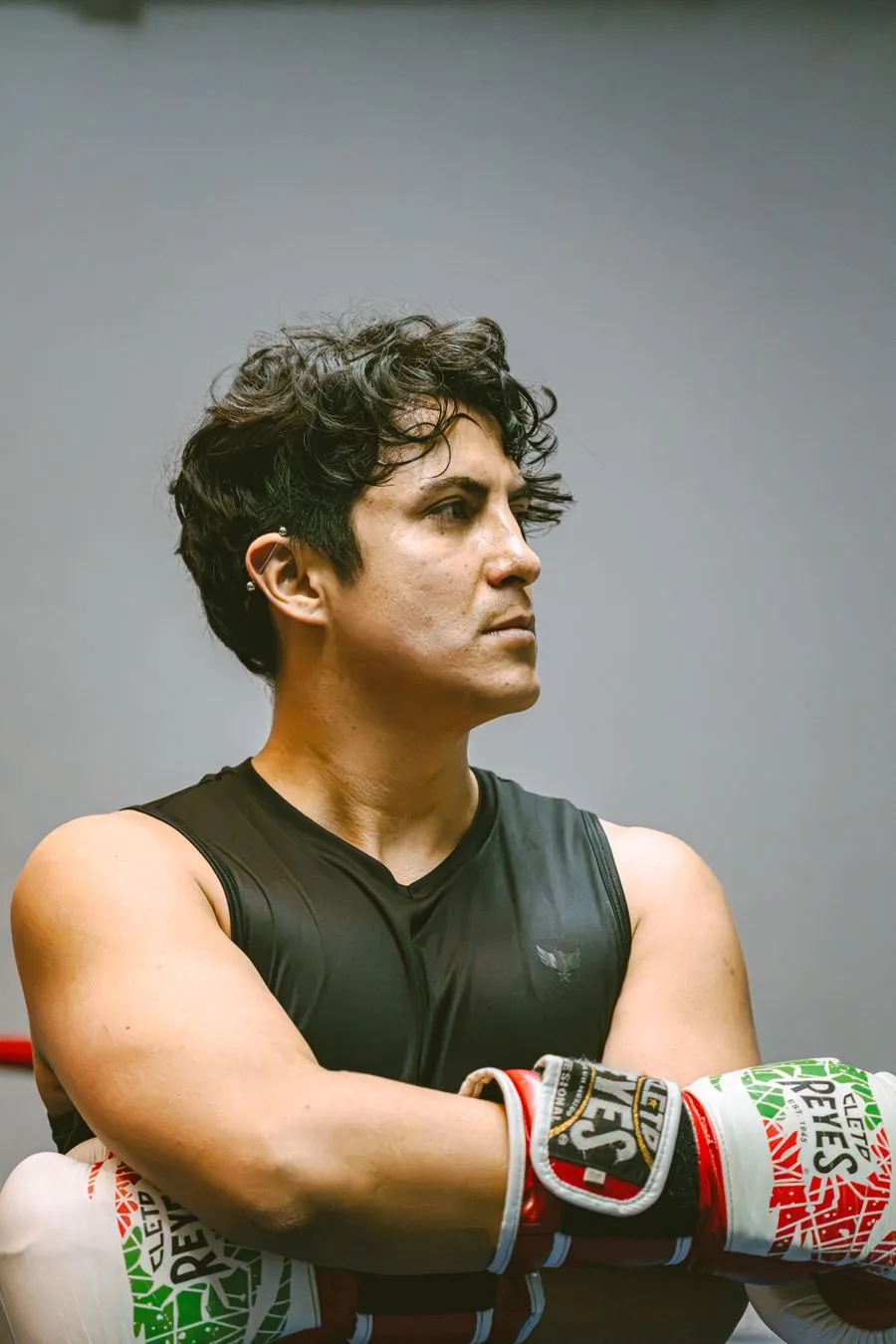 Boxer in wrapped gloves photographed in a dark gym