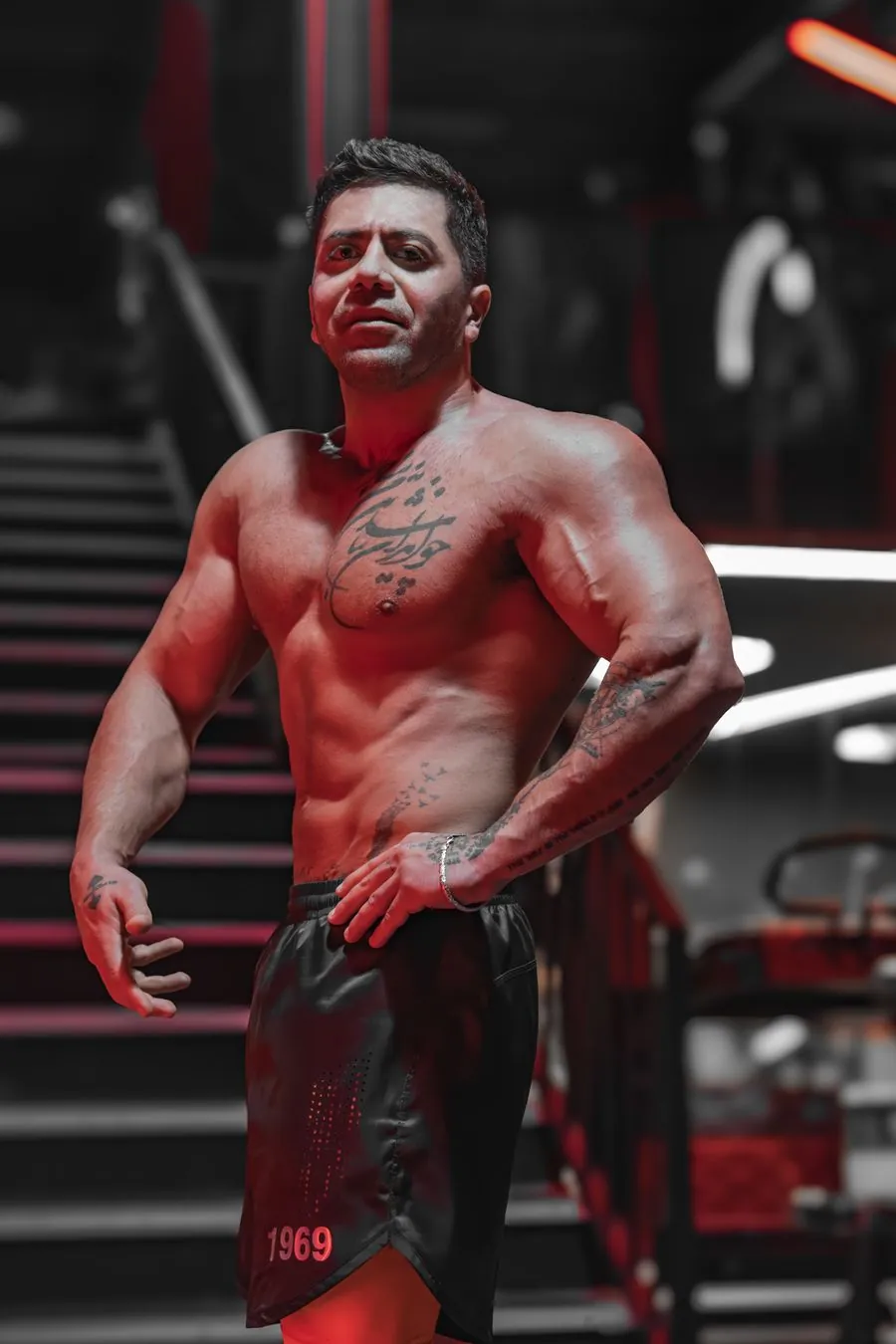 Athlete posing under red gym lighting