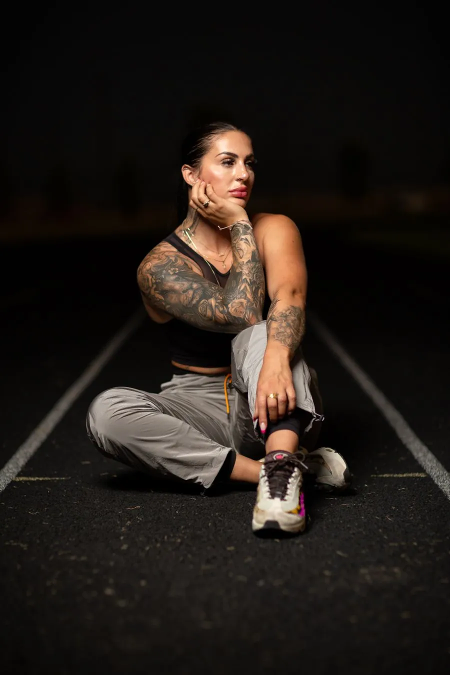 Athlete resting on a barbell in a low-lit gym