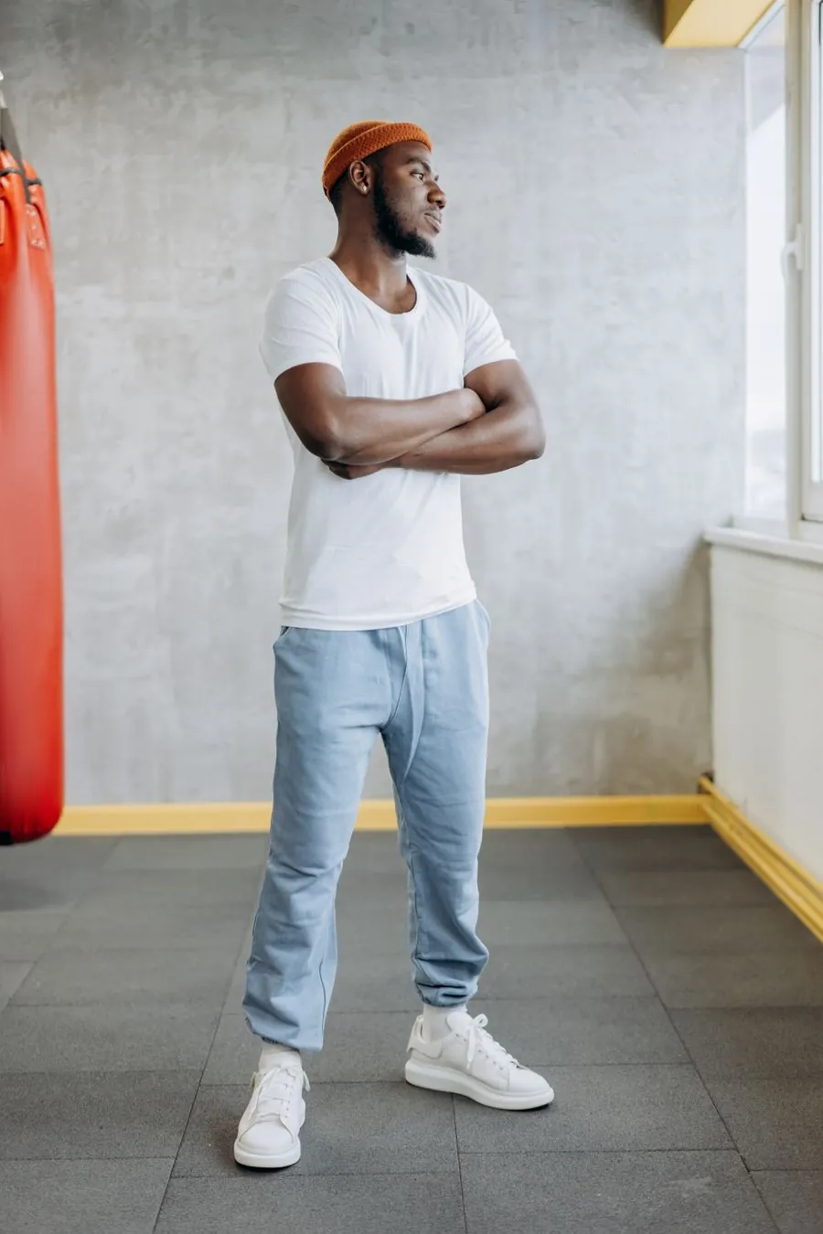 Person in a white t-shirt standing beside a heavy bag