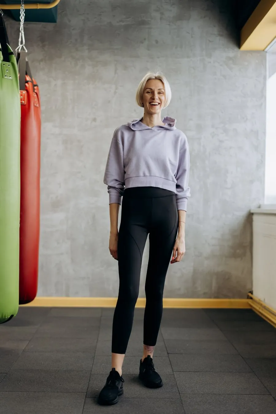 Person in a hoodie and leggings smiling before training