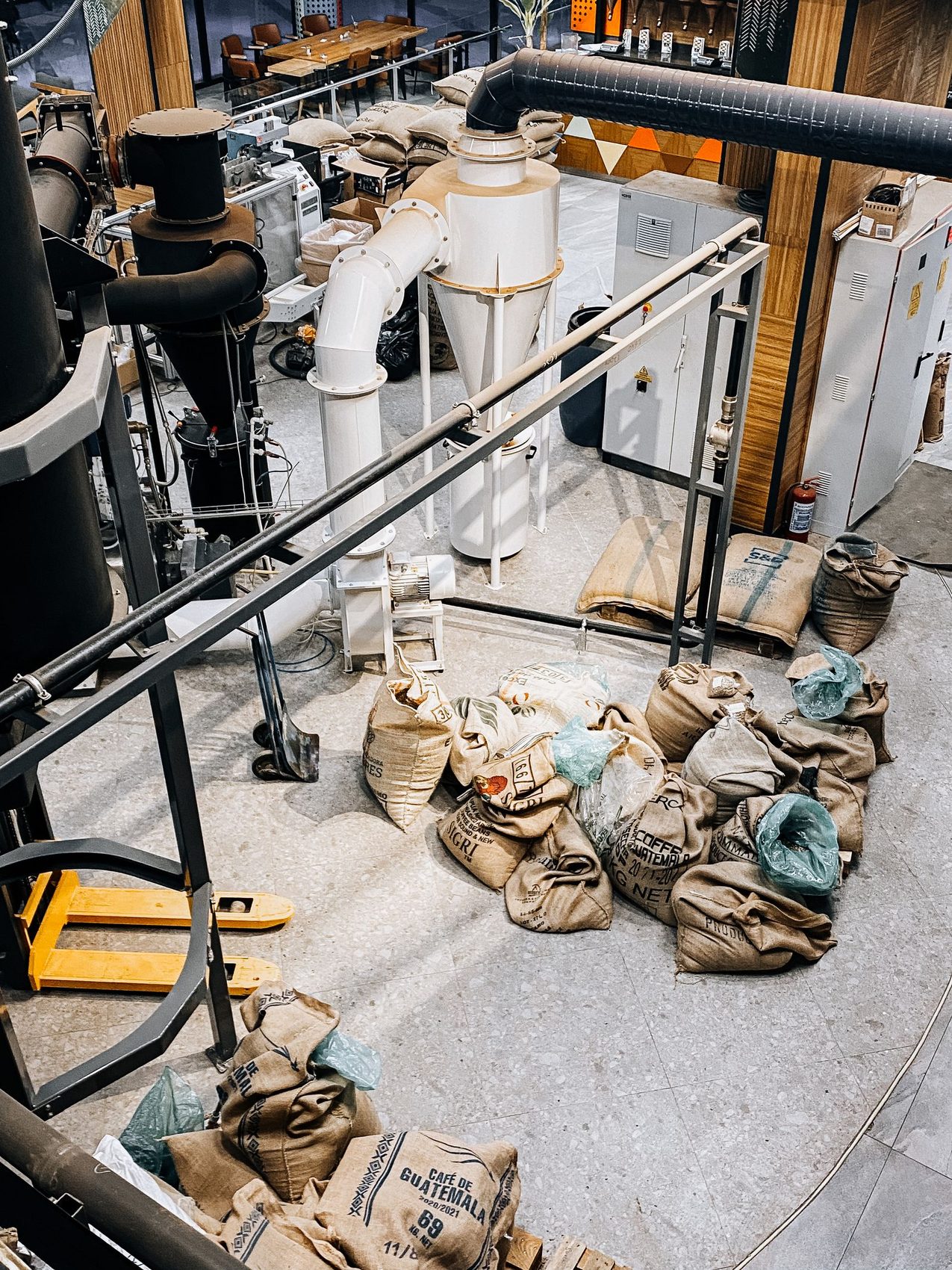 Industrial exhaust pipework and jute sacks inside a roastery