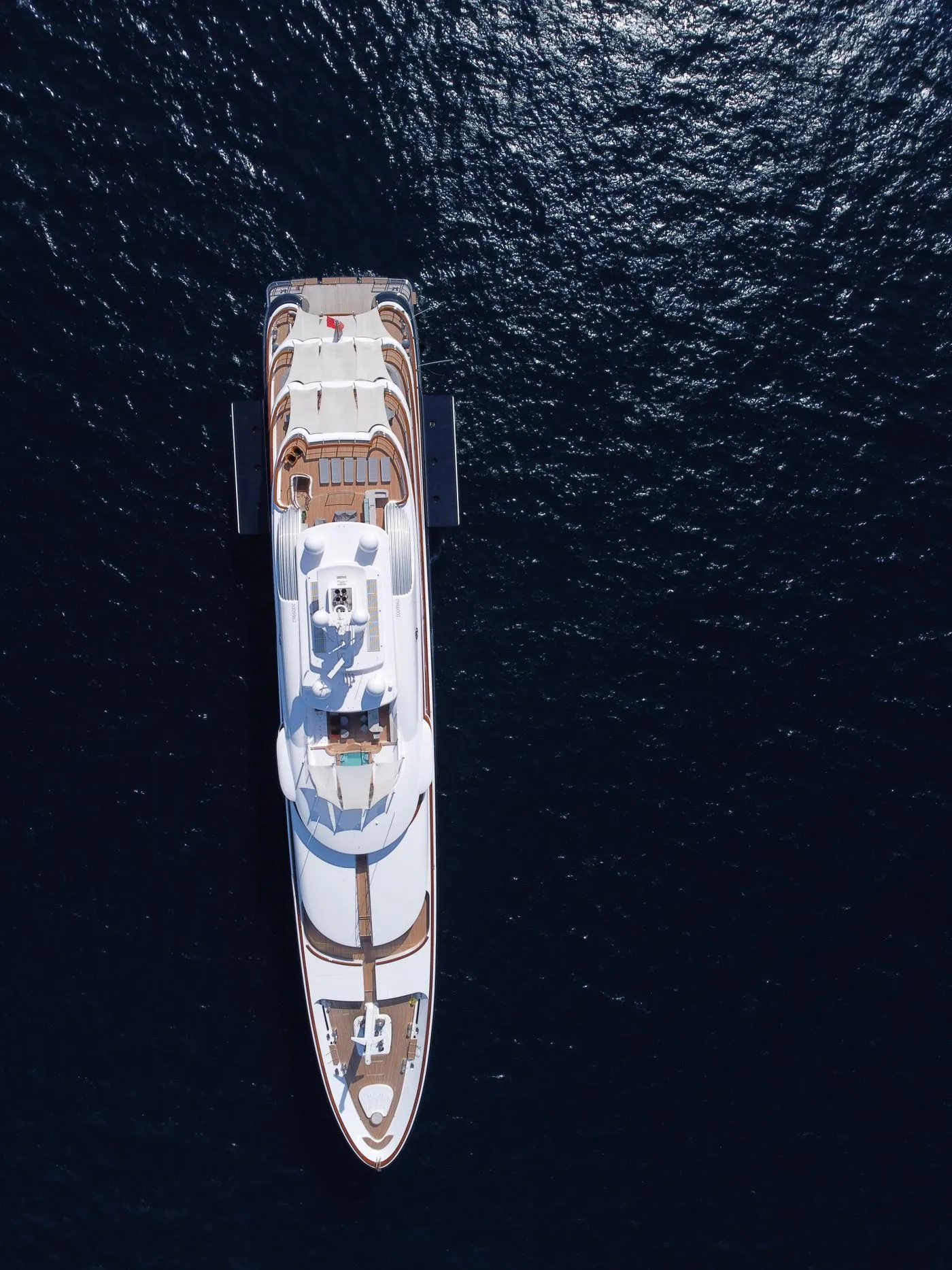 Aerial view of a superyacht under way on deep blue water