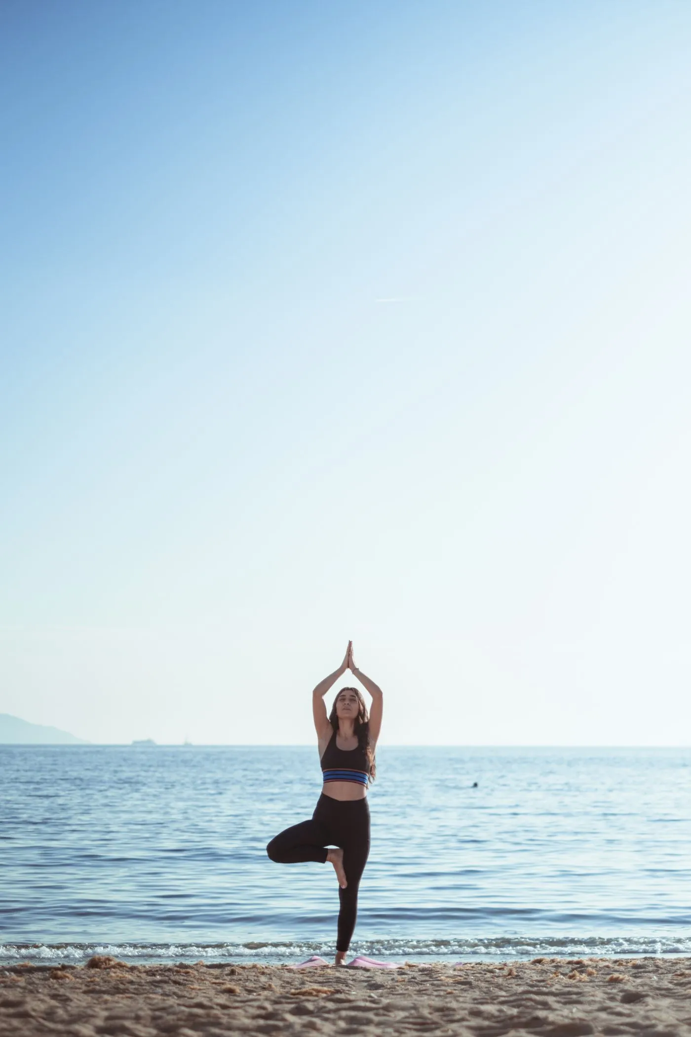A yoga pose held on a beach at sunrise