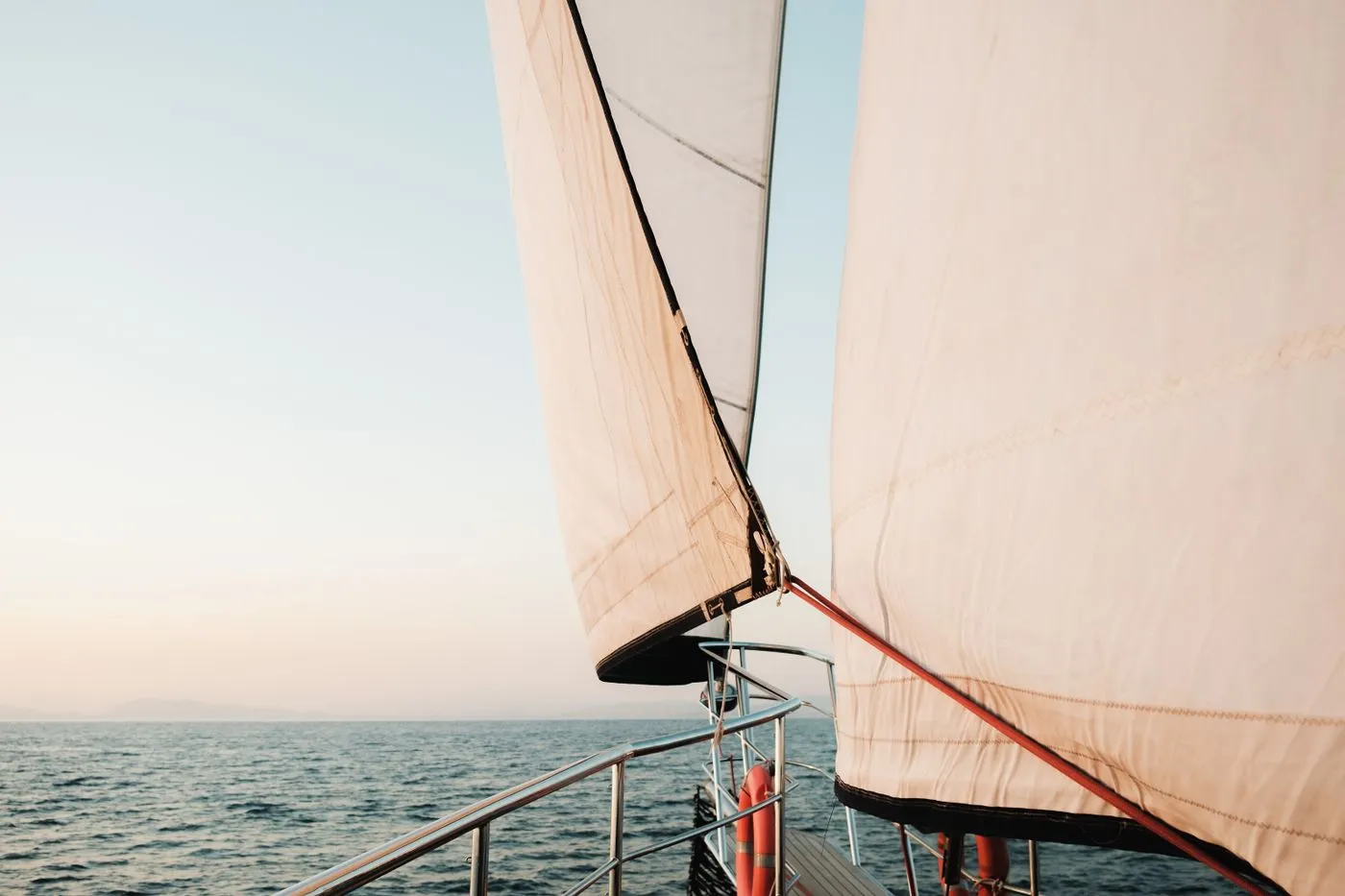 White sails against a wide open horizon