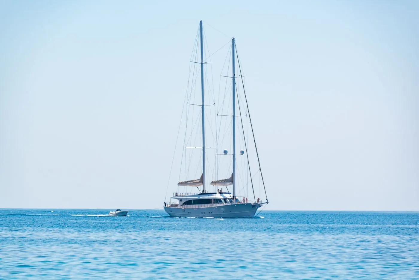 Elegant sailing yacht under full sail on calm blue water