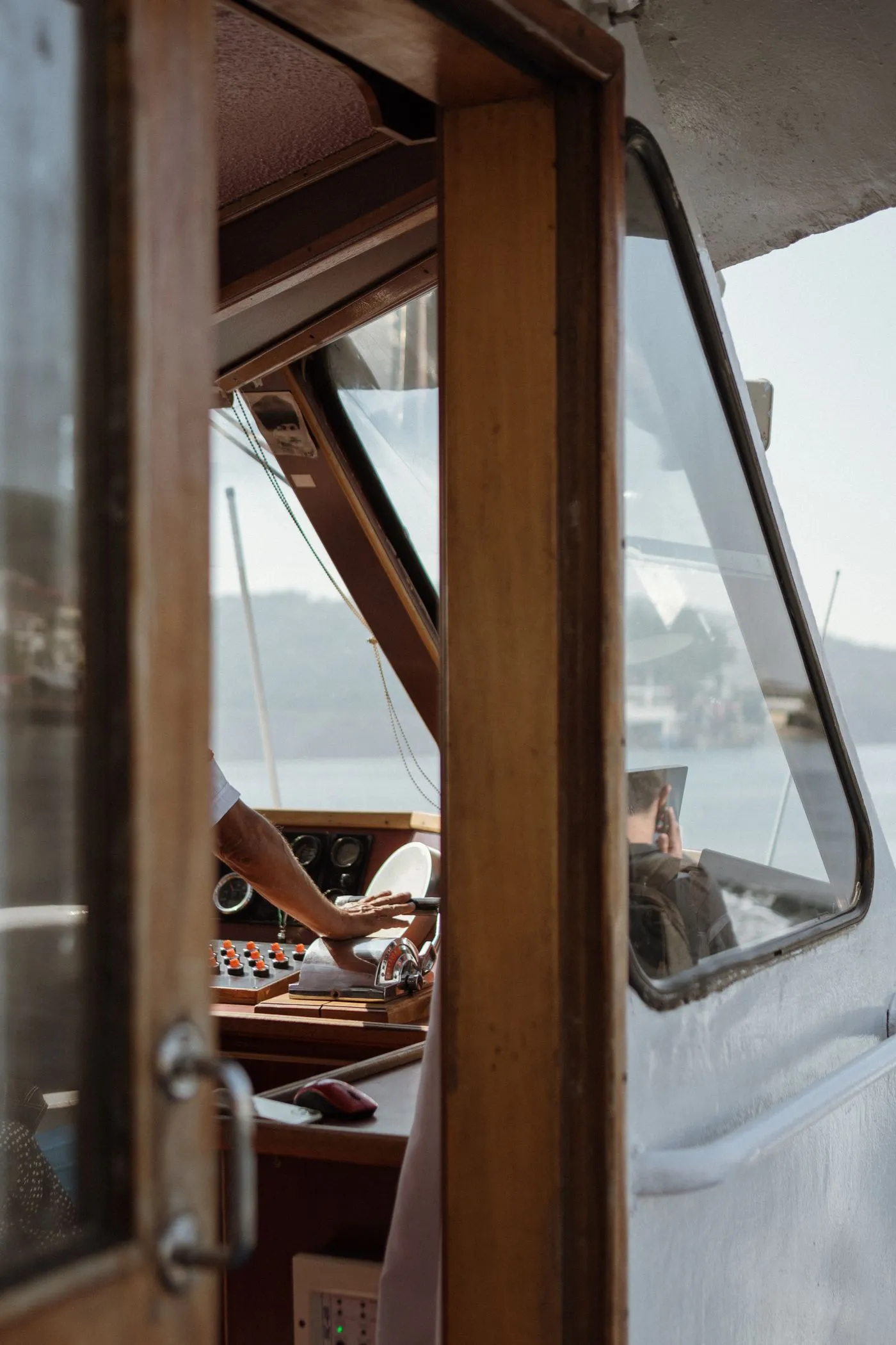A captain at the controls of a vessel, hands on the wheel