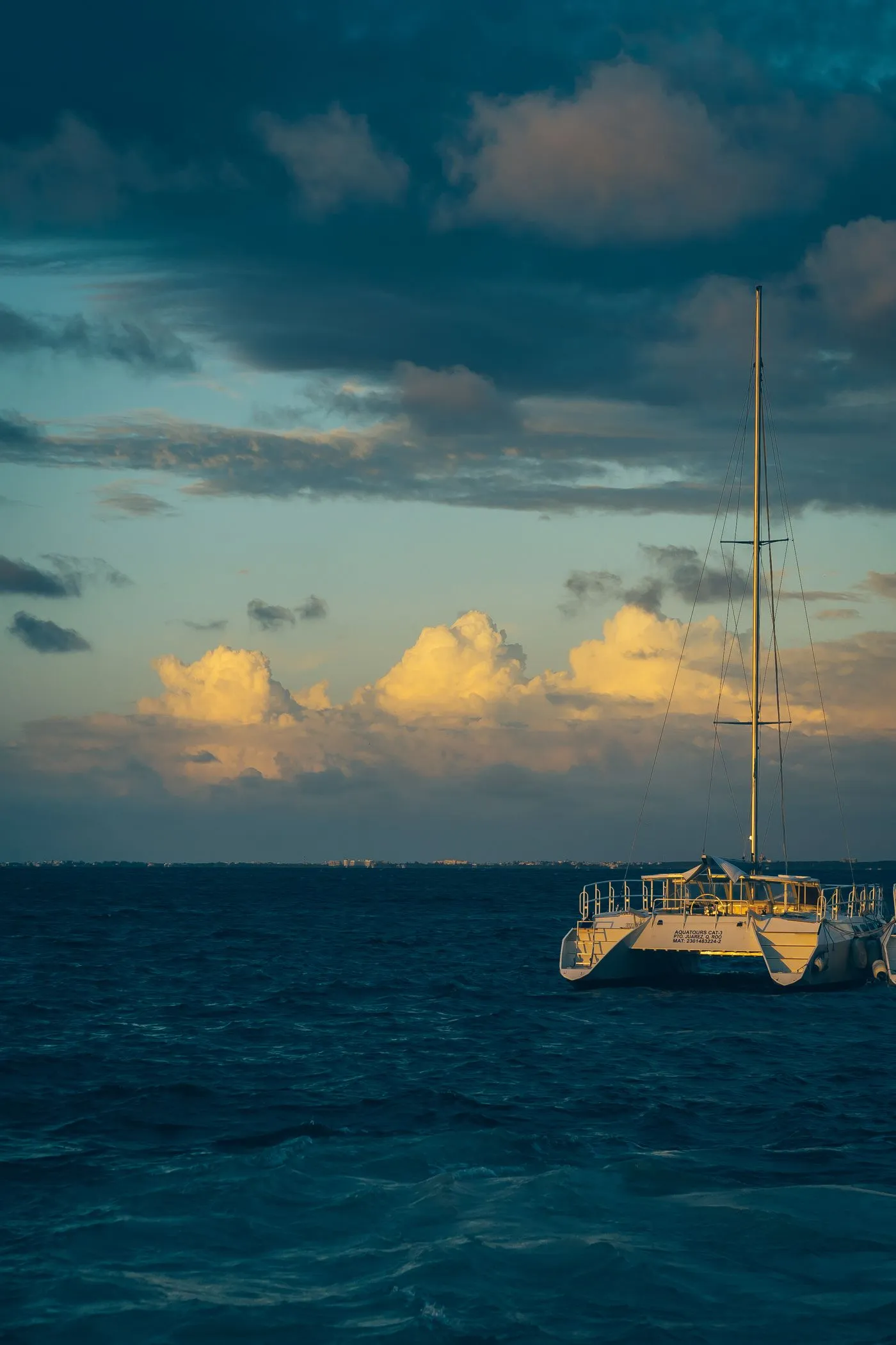 A solitary sailing yacht on the open sea under a dramatic sky