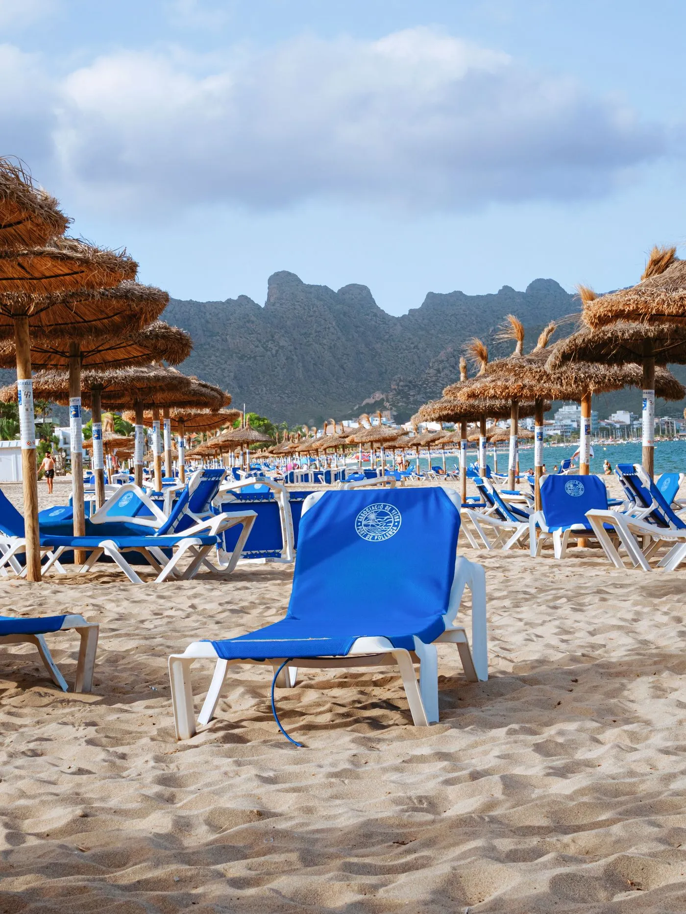 Blue loungers and straw umbrellas on a beach