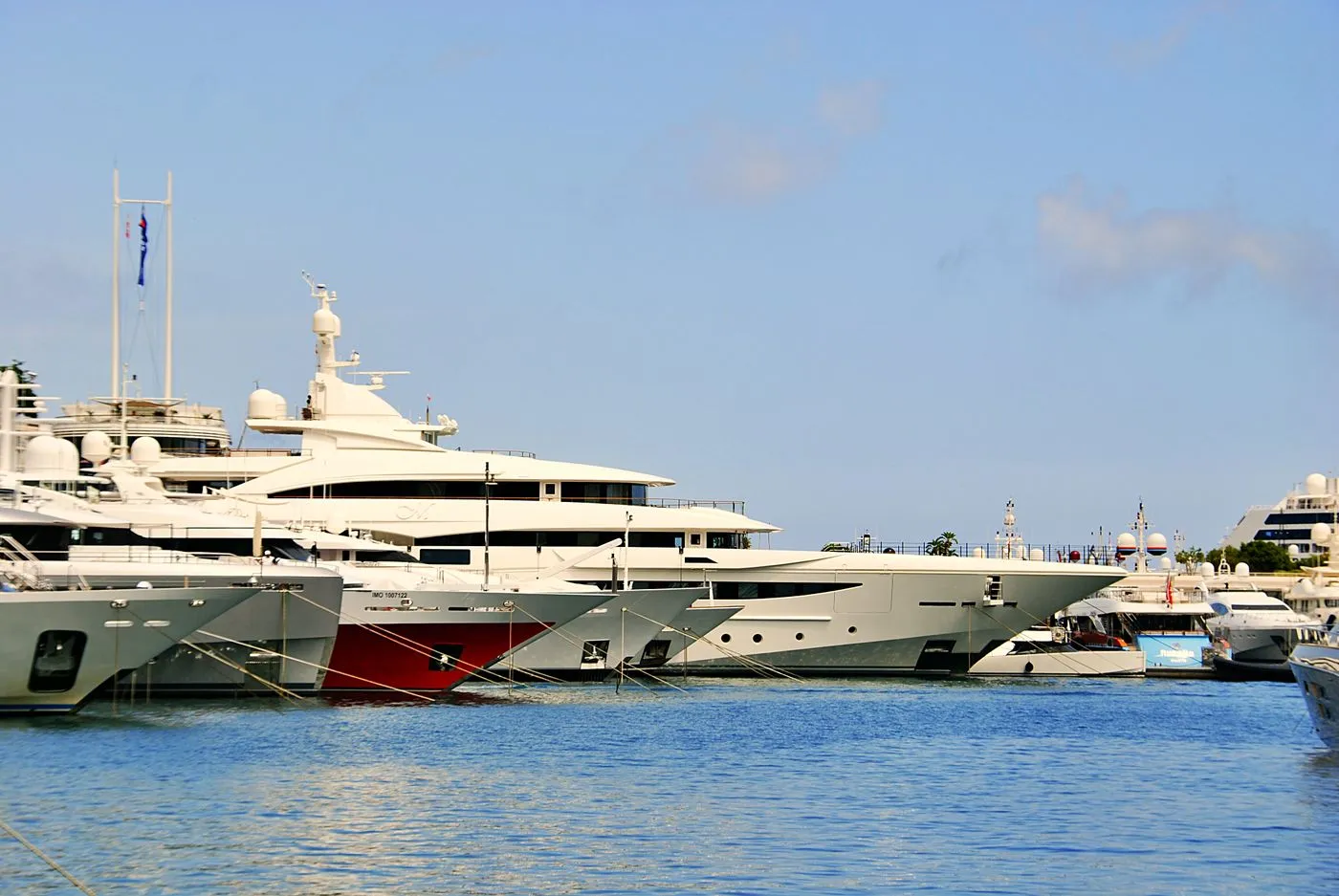 Luxury yachts moored in a sunlit Mediterranean marina