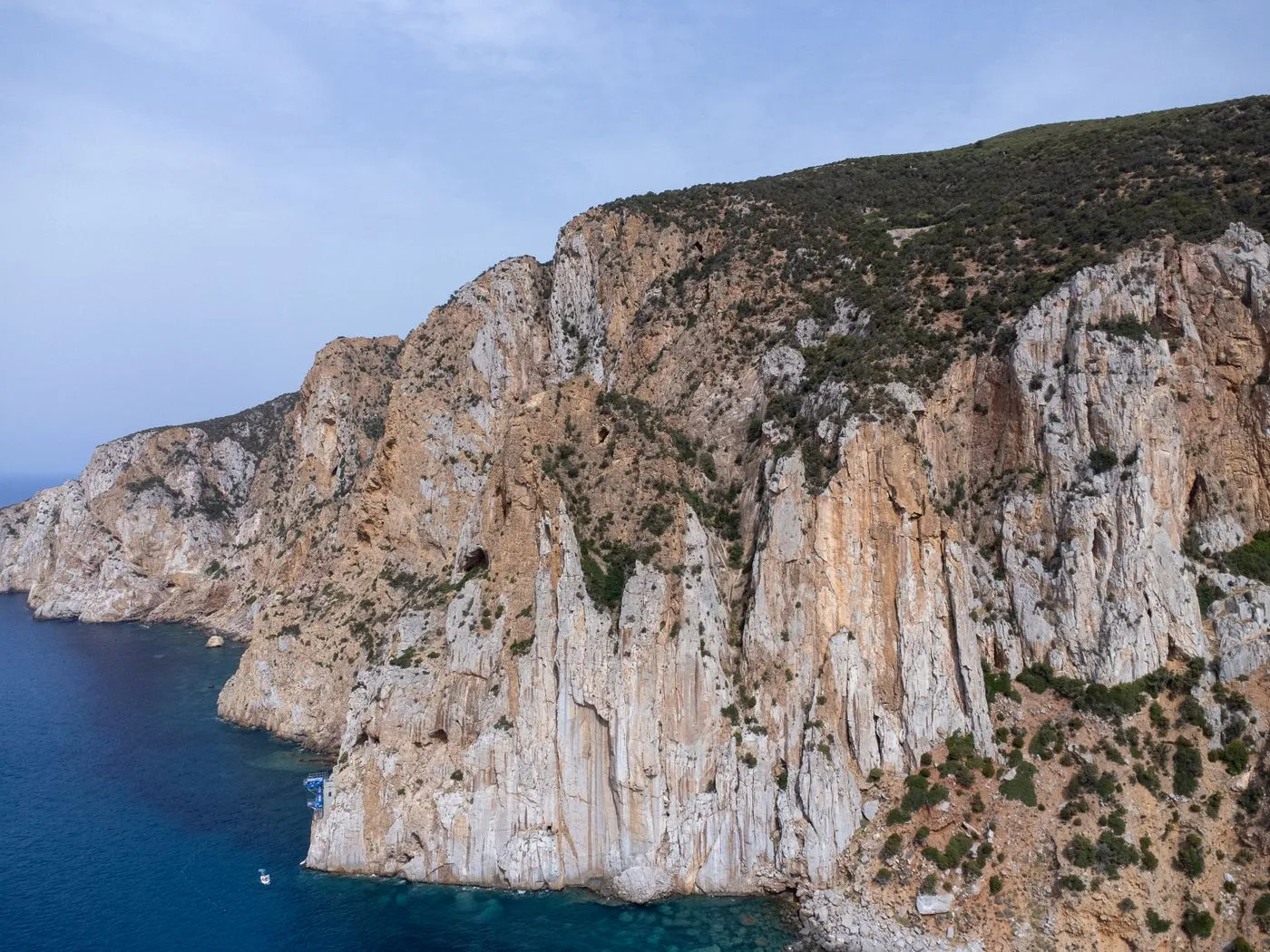 Rugged coastal cliffs above clear Sardinian water