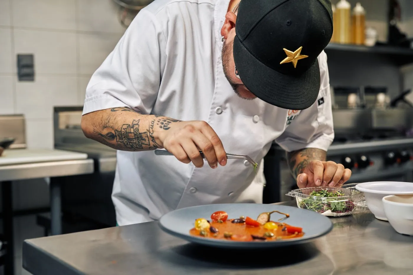 Chef finishing a plated dish in a professional galley