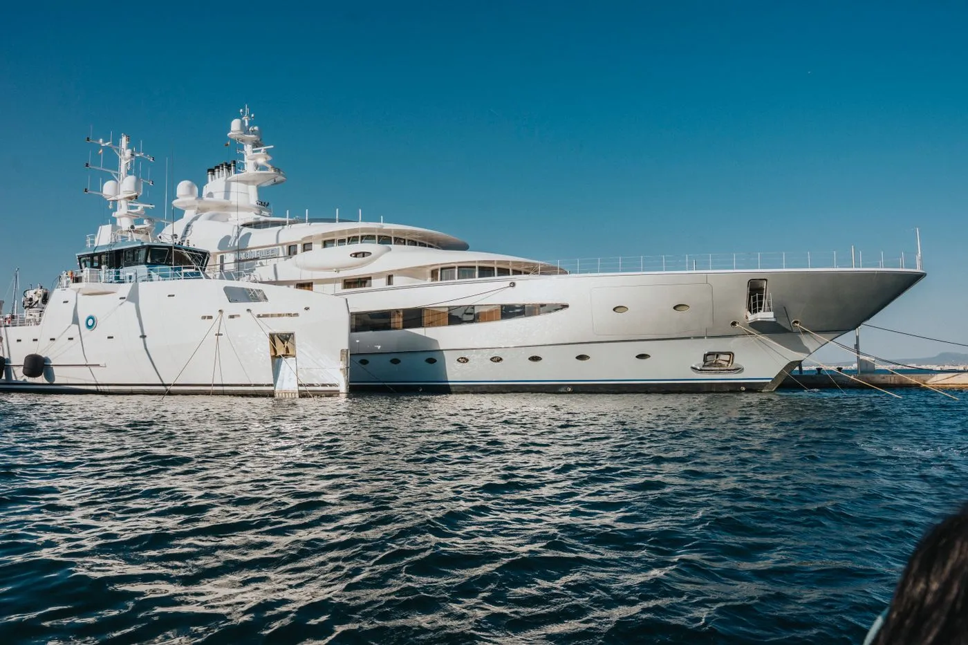 Large explorer yacht at rest on calm water under a clear sky