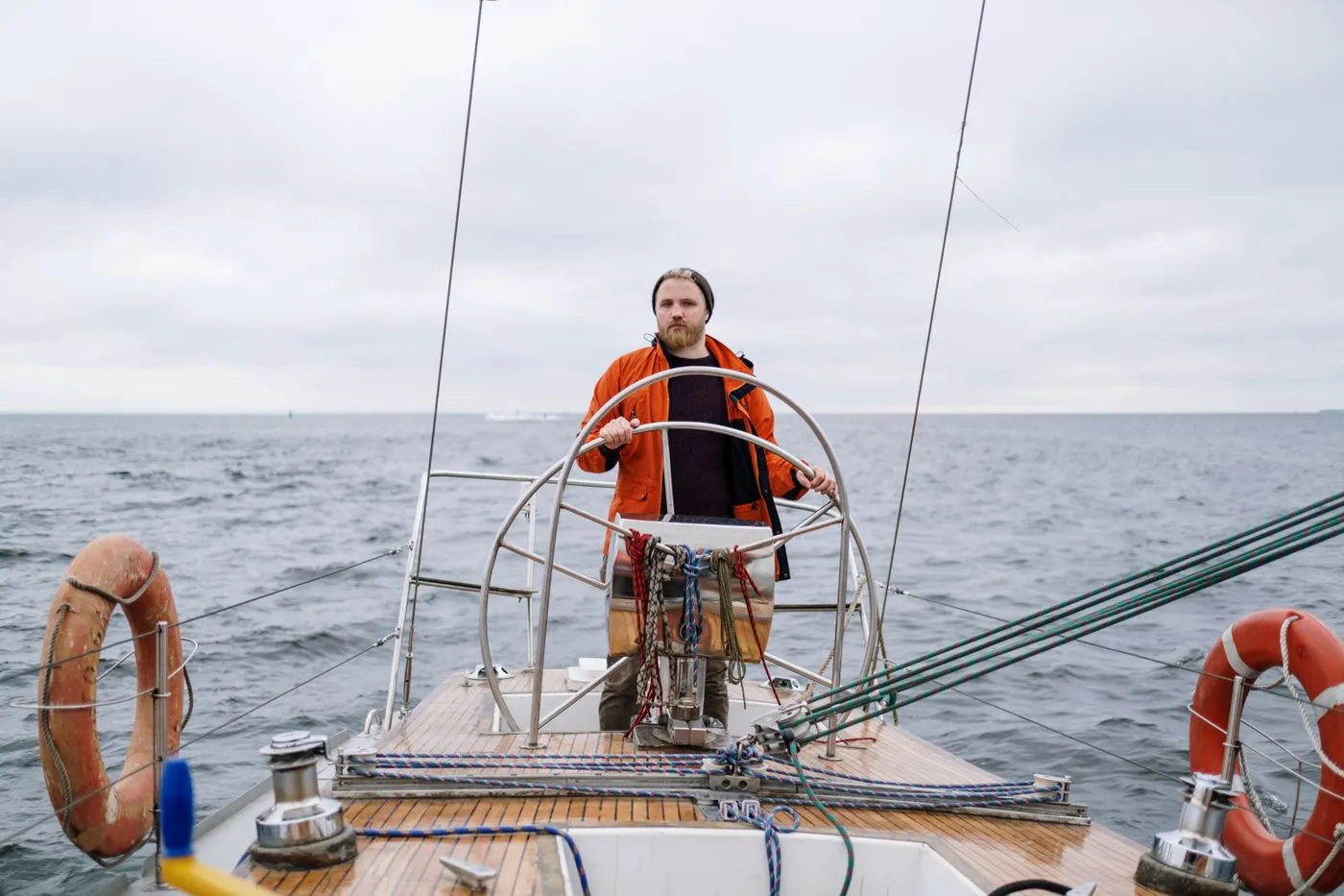 Crew member trimming a sail on open water
