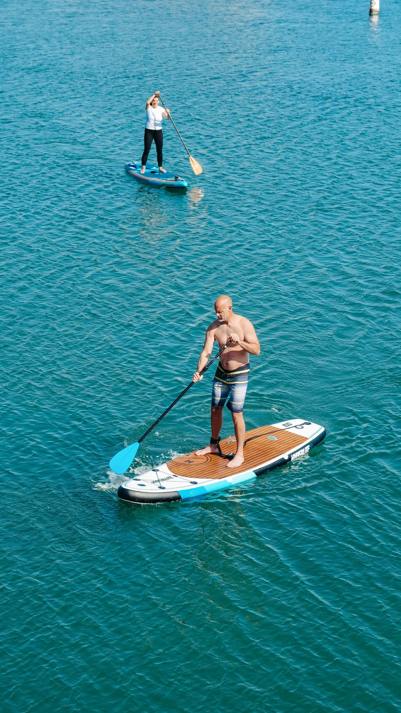 Paddleboarders on calm water on a bright day