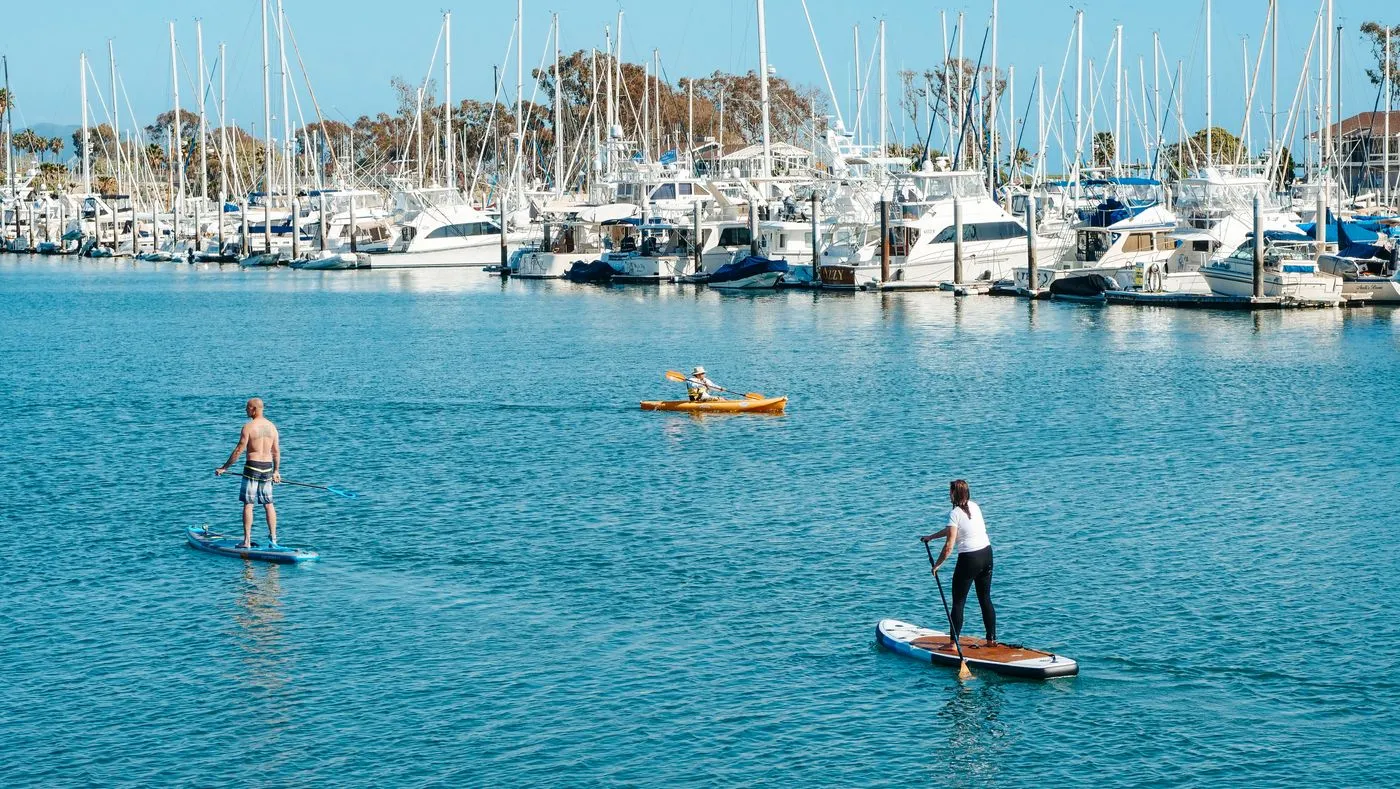 Paddleboarders and a kayaker on calm water