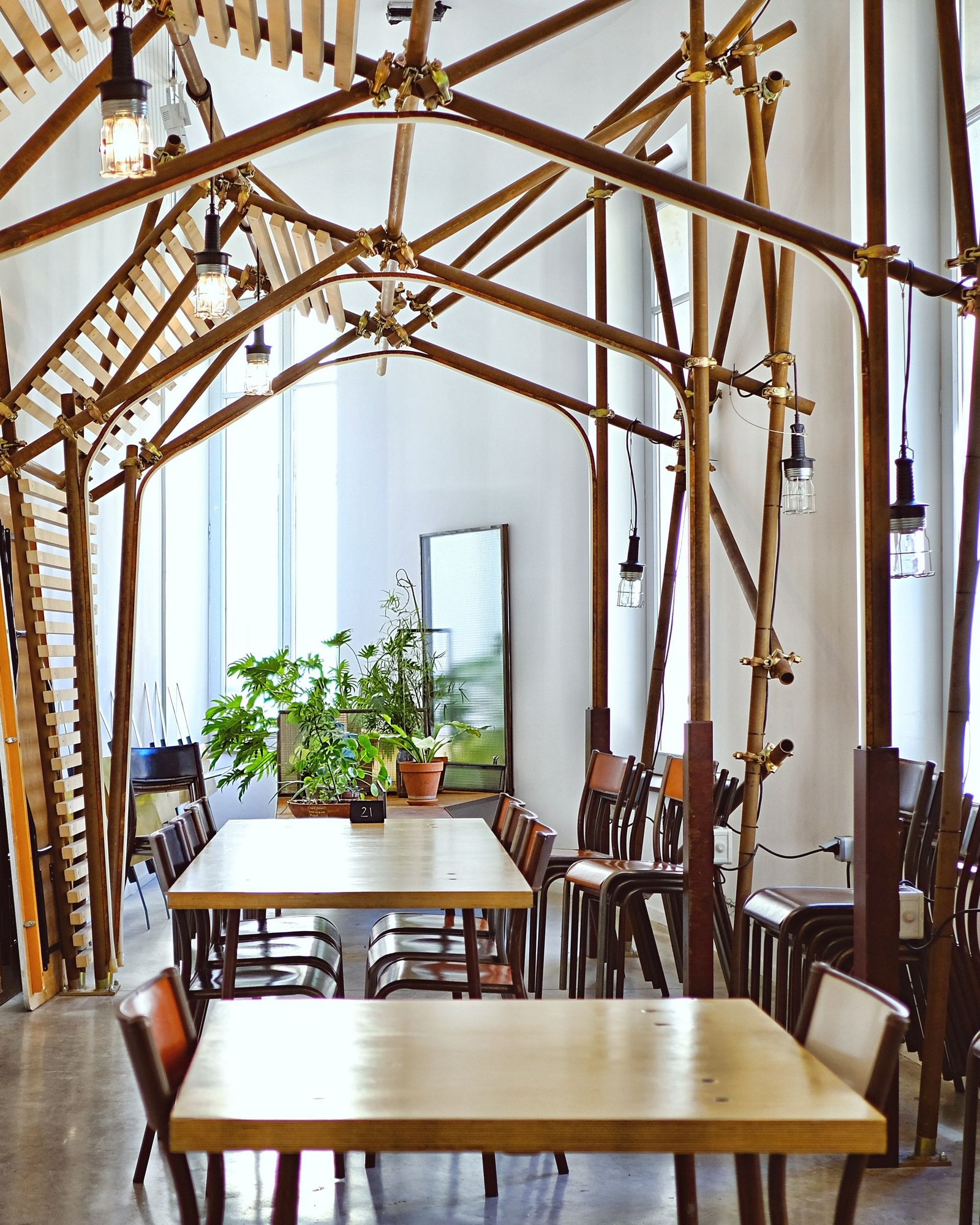 Dining tables under an exposed steel truss and tie-rod structure