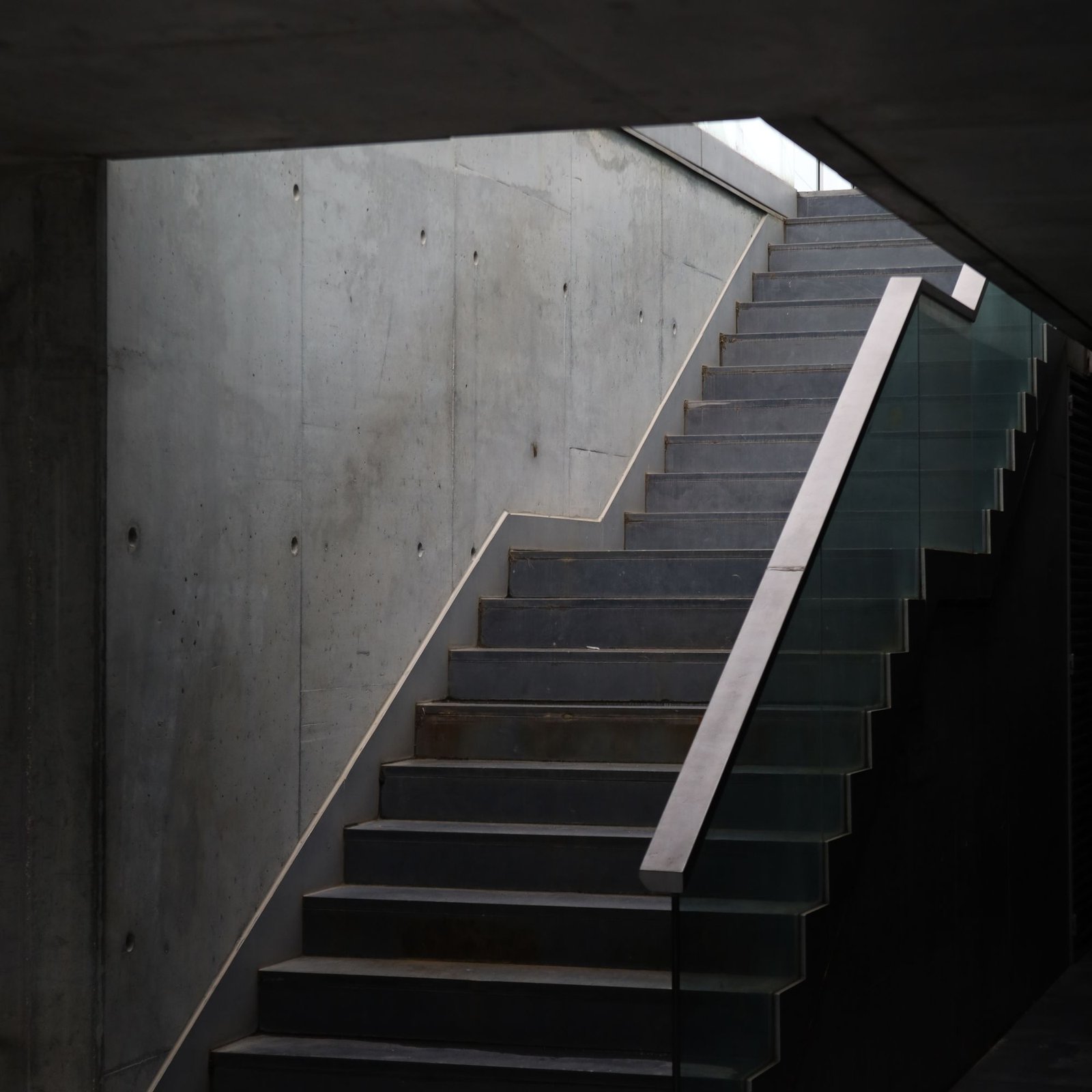 Minimal concrete staircase against a plain wall
