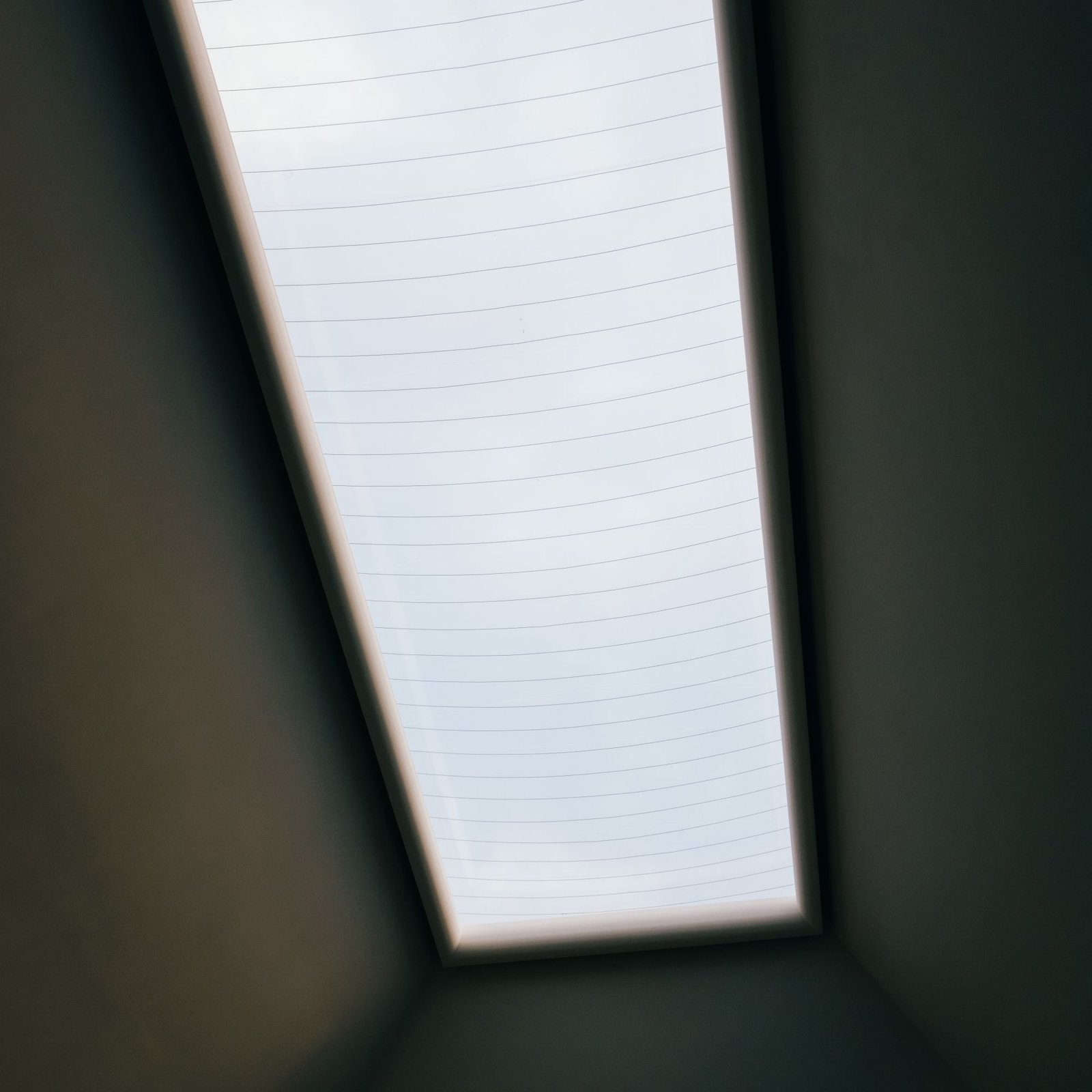 Long slot rooflight glowing in a dark ceiling