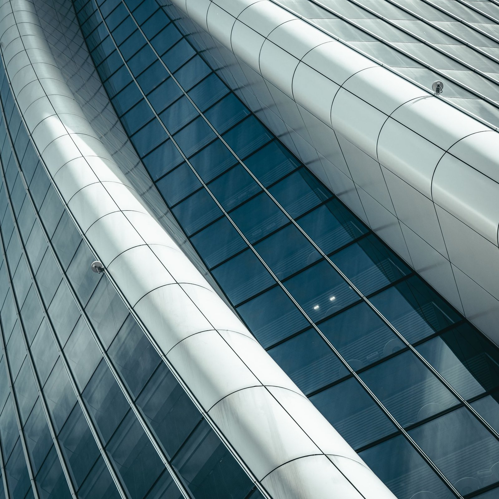Curved glass and metal facade catching low light
