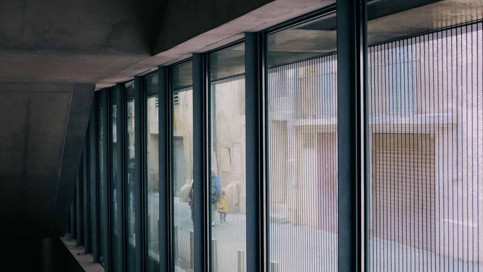 Long corridor lined with windows looking onto the city