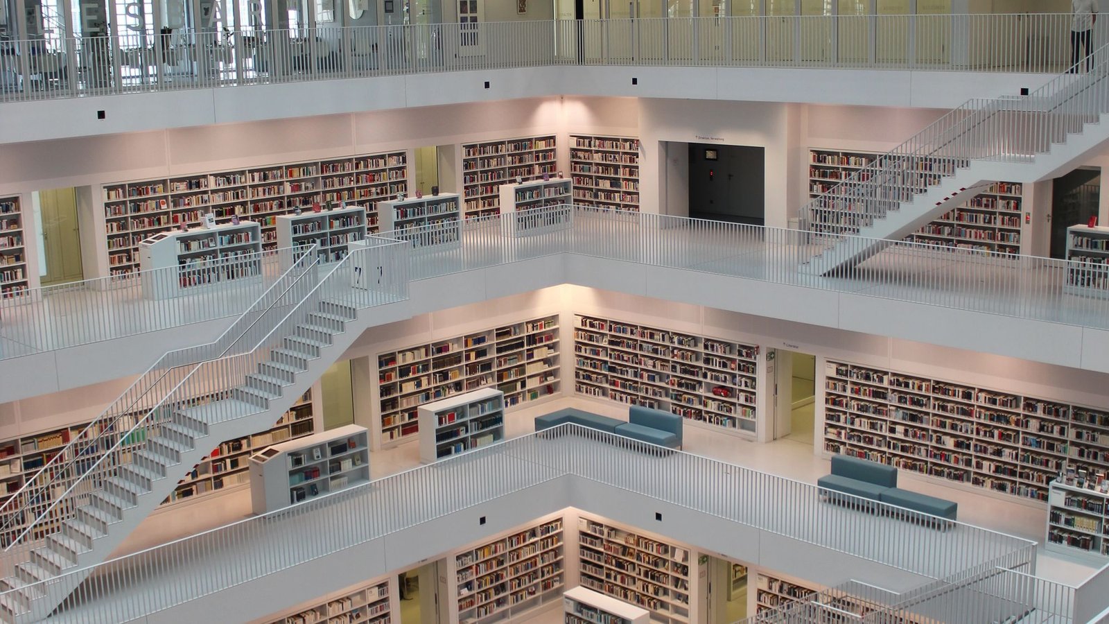 Bright multi-level library interior with long reading tables