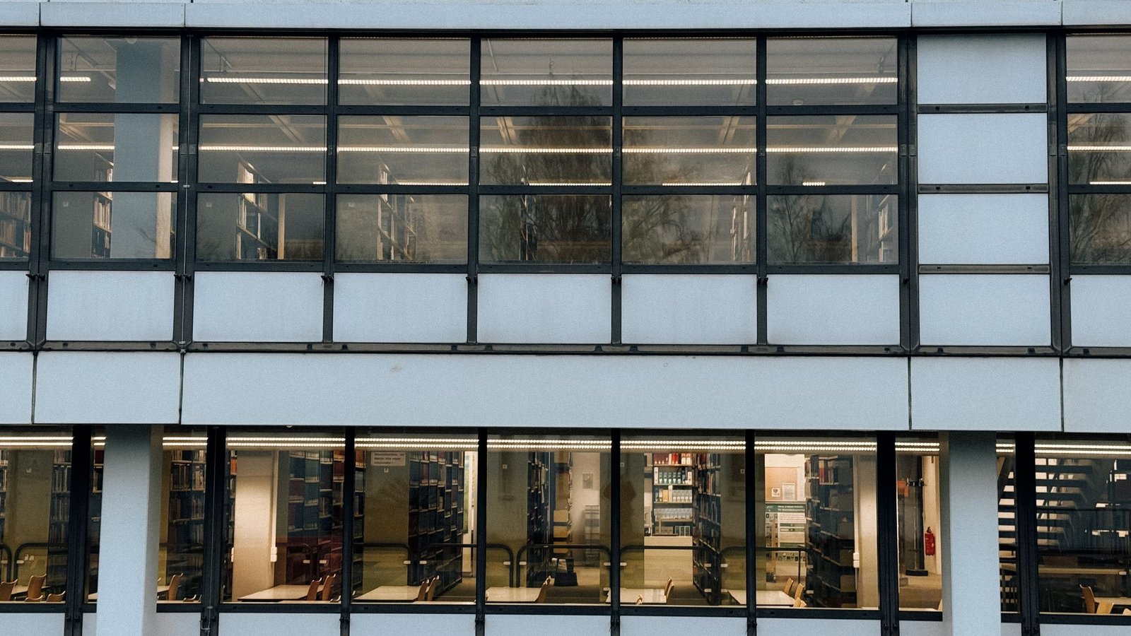 Long modernist glass building with slender mullions and a deep colonnade