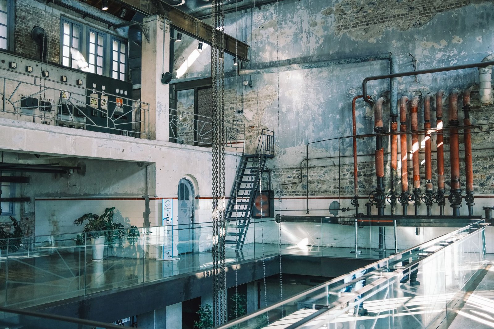 Converted industrial hall with retained pipework, brick and inserted structures