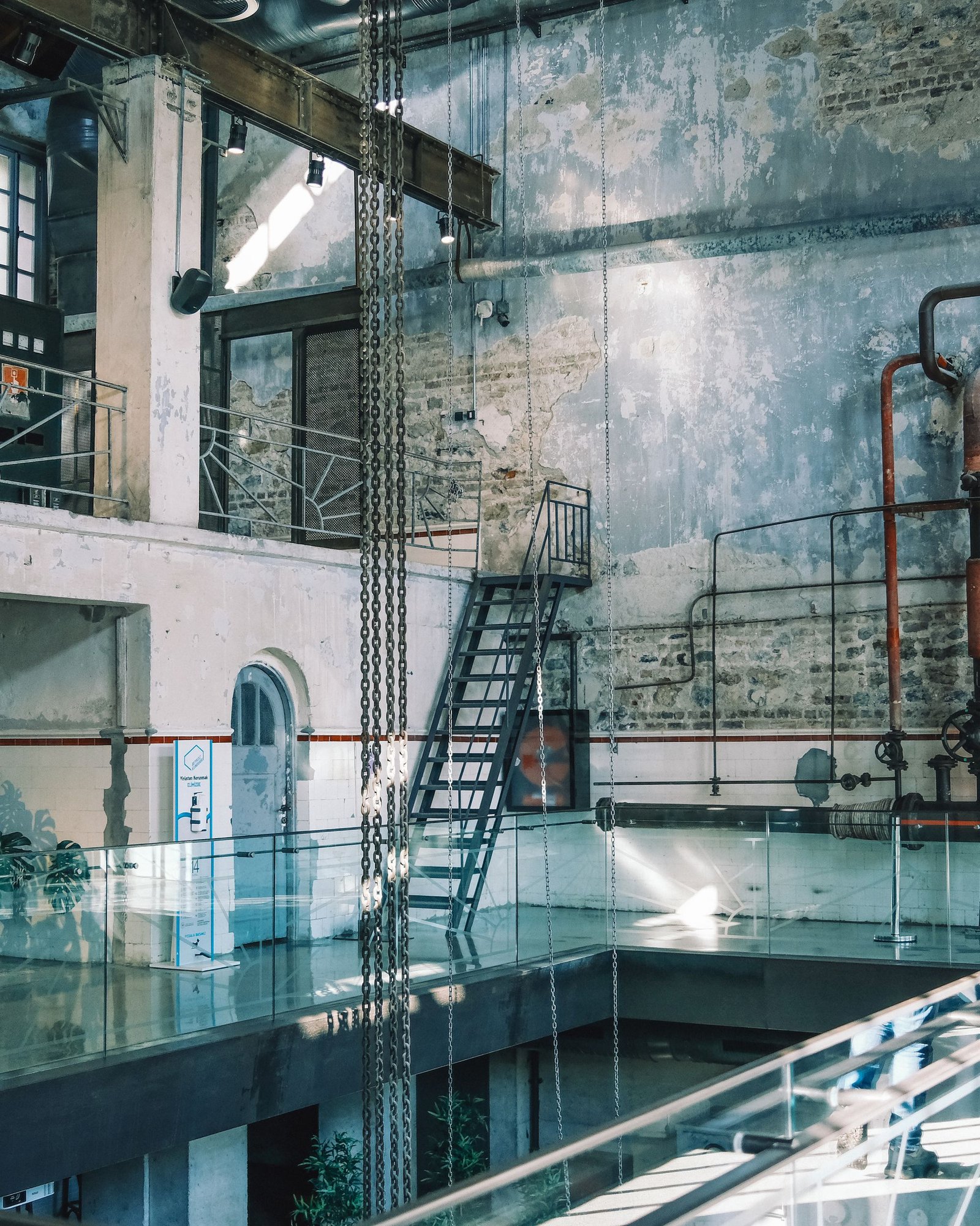 Converted industrial hall with retained pipework, brick and inserted structures