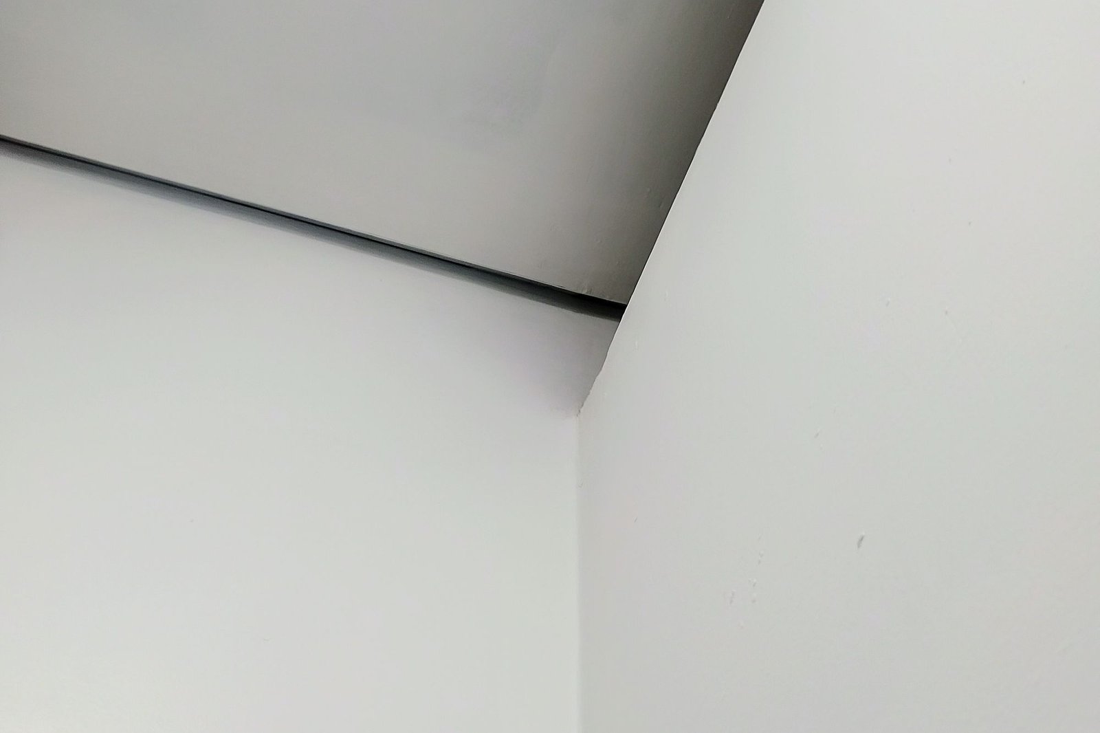 Pale interior corner where two plaster planes meet in soft light