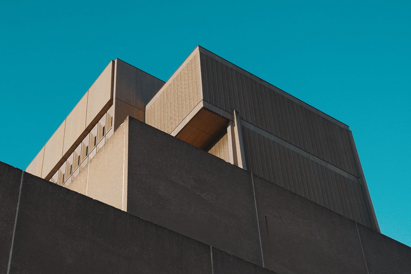 Angular concrete building mass photographed against a deep blue sky