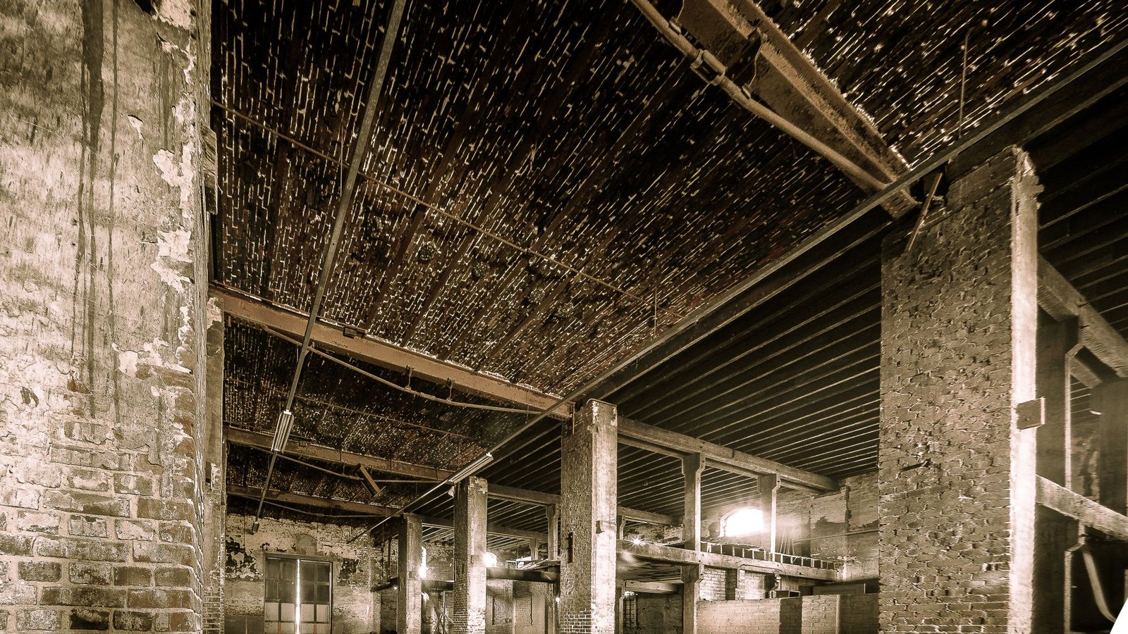 Long hall with a timber roof structure carried on rows of masonry columns