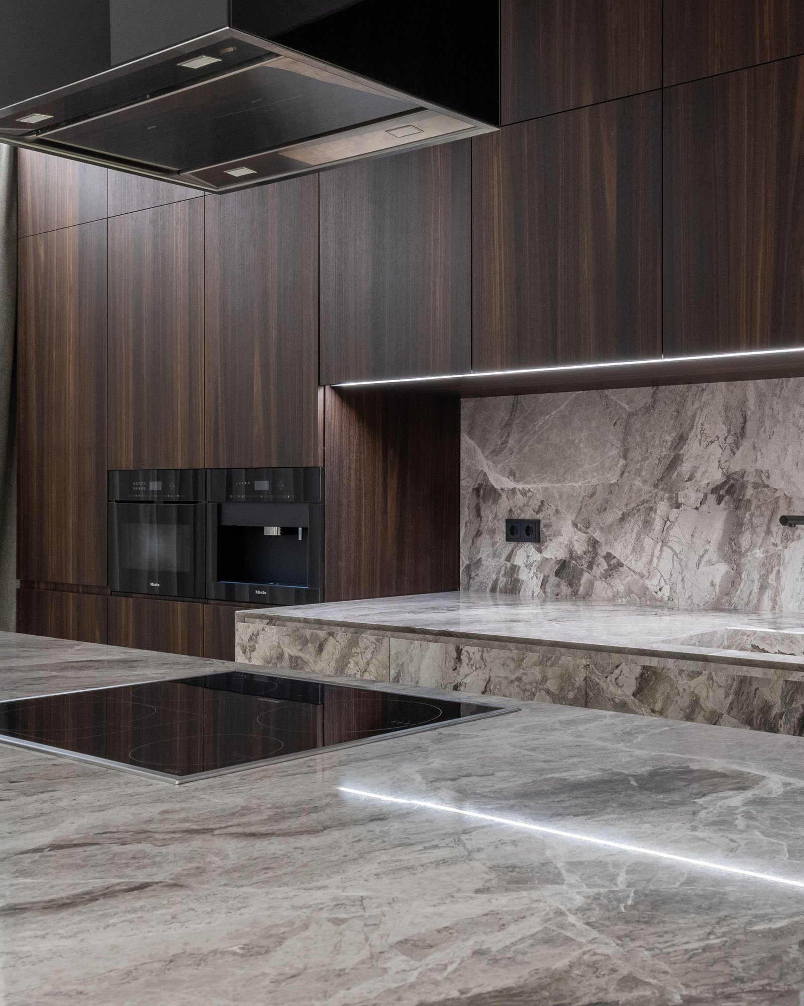 Dark stone kitchen with a long island and integrated joinery