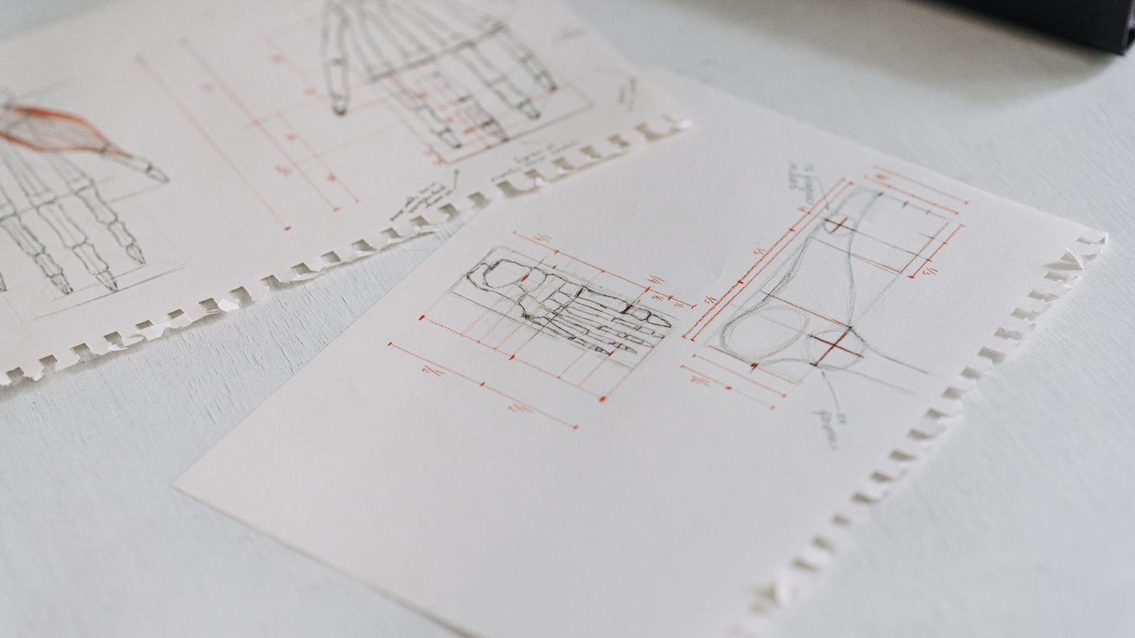 Soft-focus technical drawings laid out in neat overlapping sheets