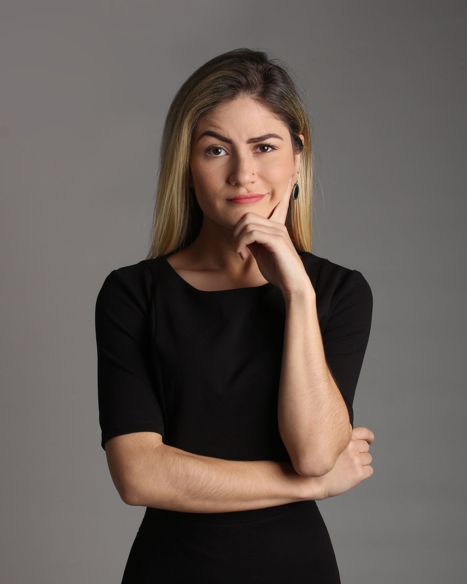 Portrait of a woman in a dark dress against a light background
