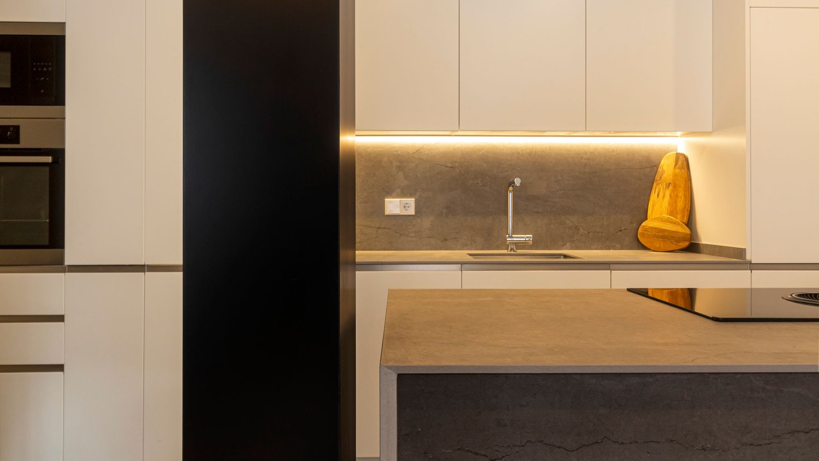 Minimal kitchen with a stone worktop and full-height joinery