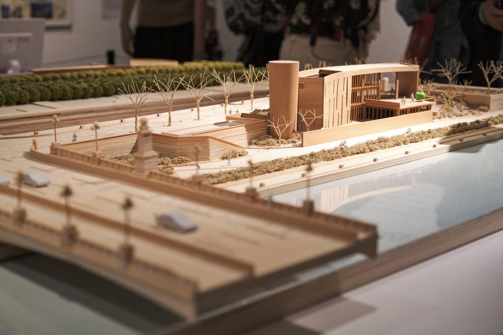 Timber and card site model showing a building set into a landscape with water