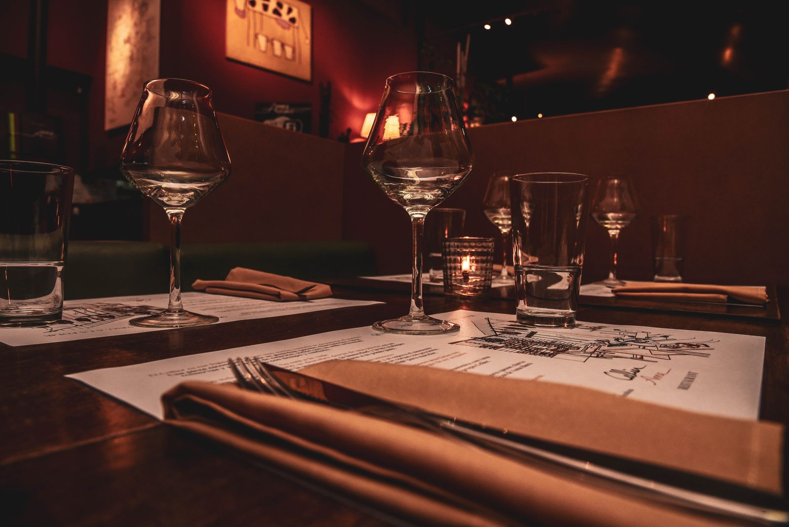 A candlelit fine-dining table set with elegant glassware