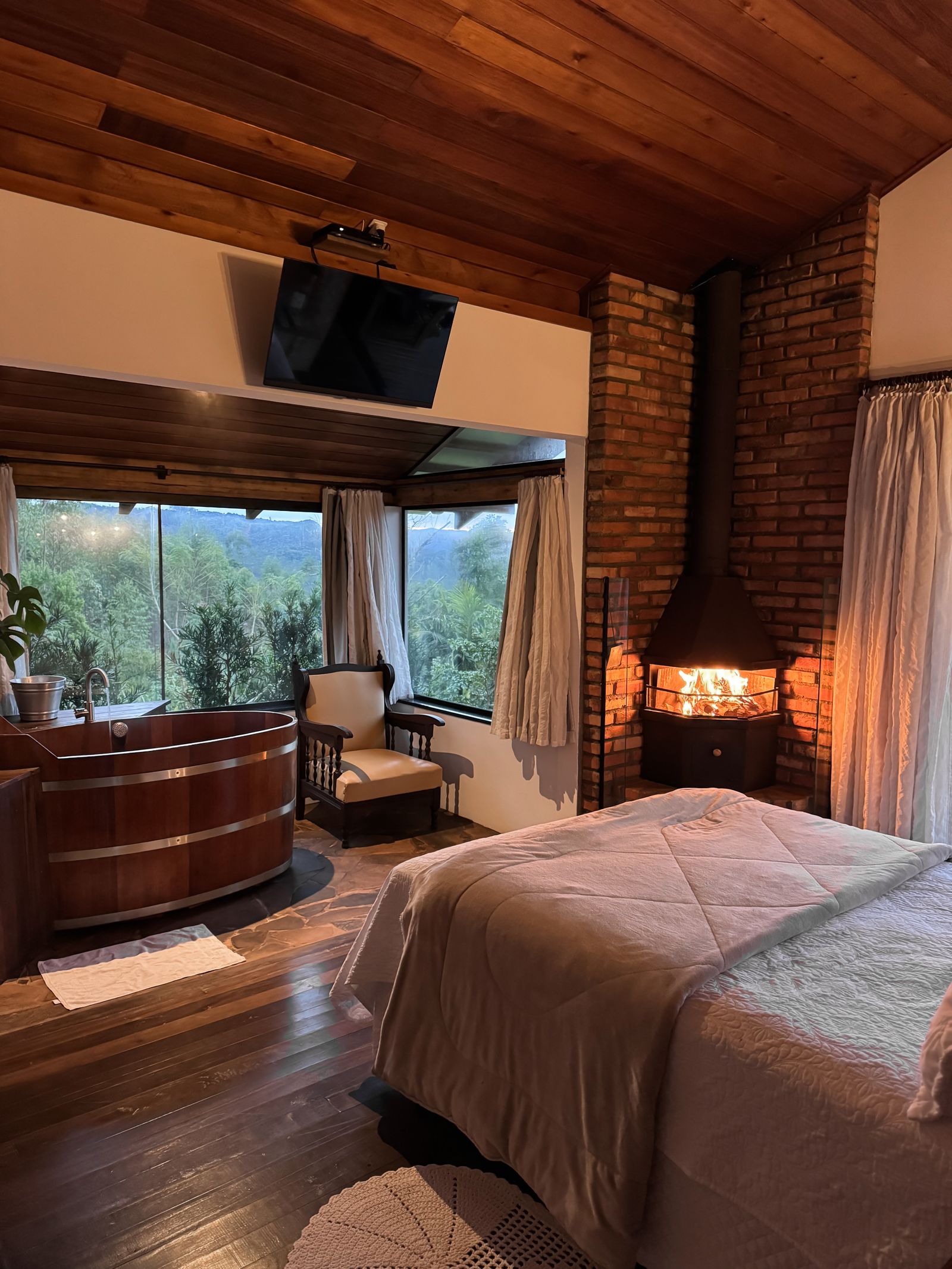 A rustic bedroom with a fireplace and mountain view