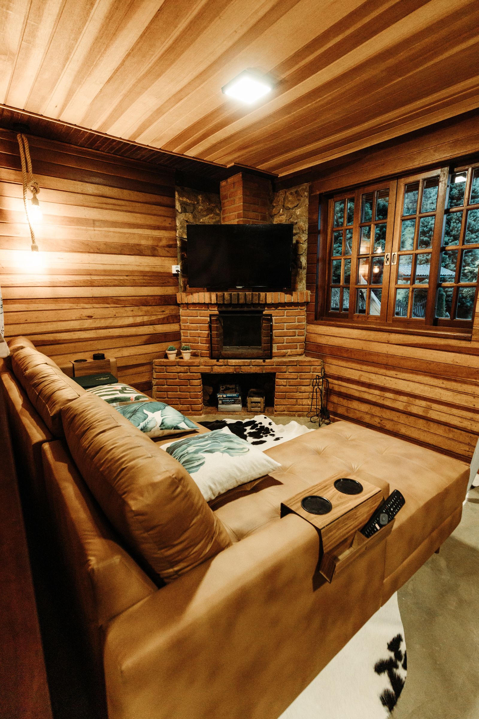 A cabin living room with a stone fireplace and warm wood